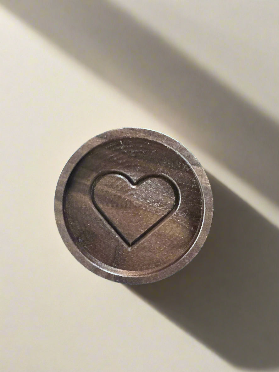 Metallic coin with a heart symbol on a blue textured background